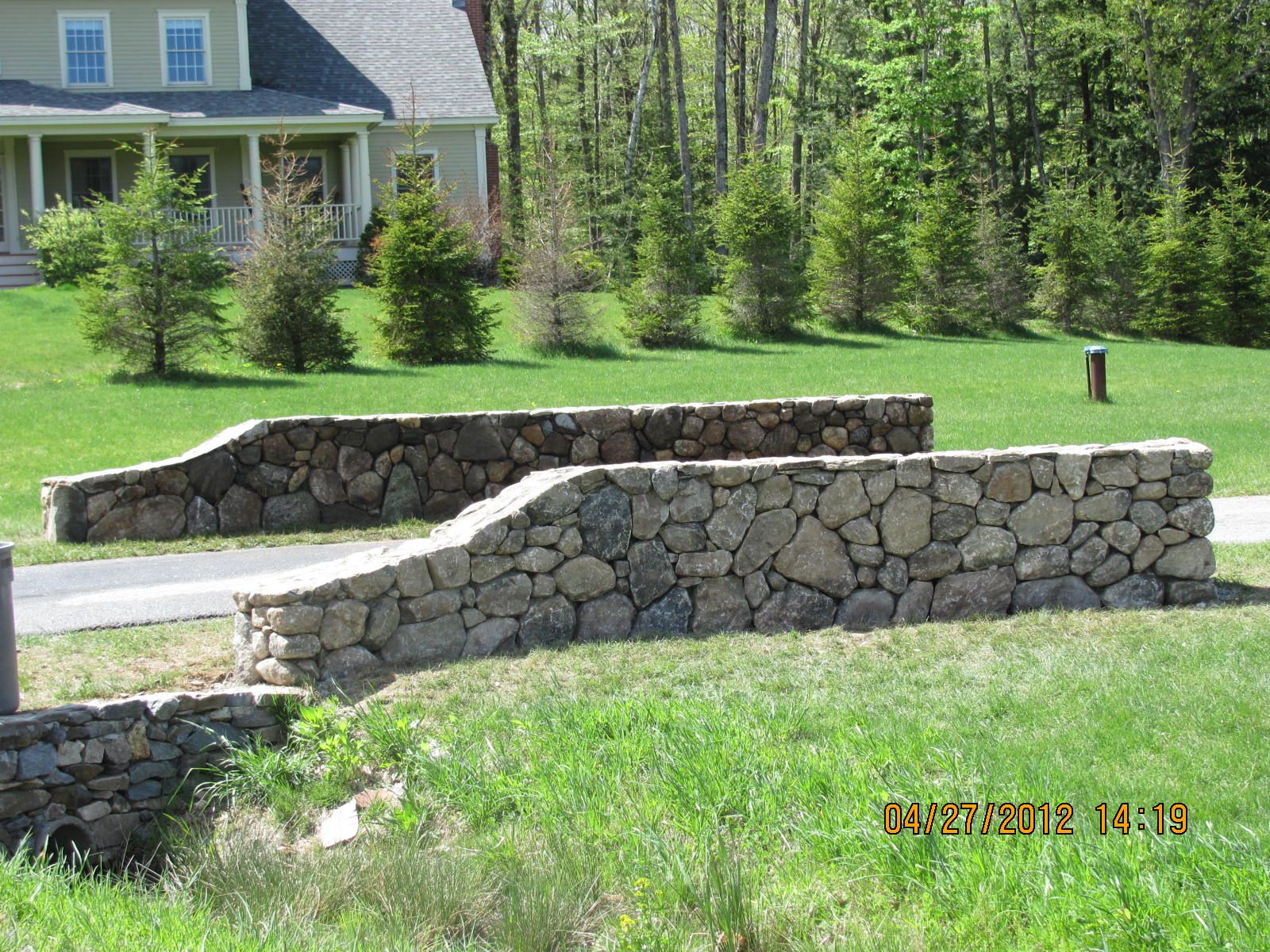 A stone wall in front of a house on april 25 2013