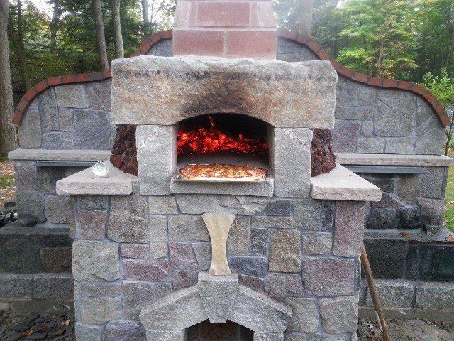 A pizza is being cooked in a stone oven