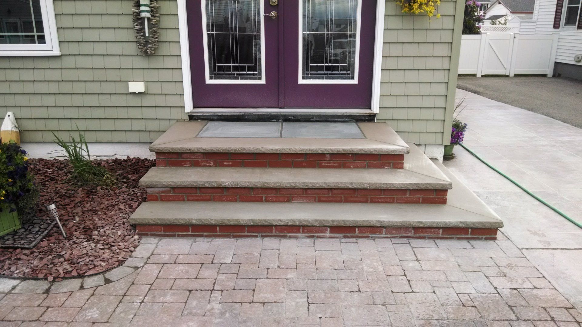 A house with a purple door and brick steps