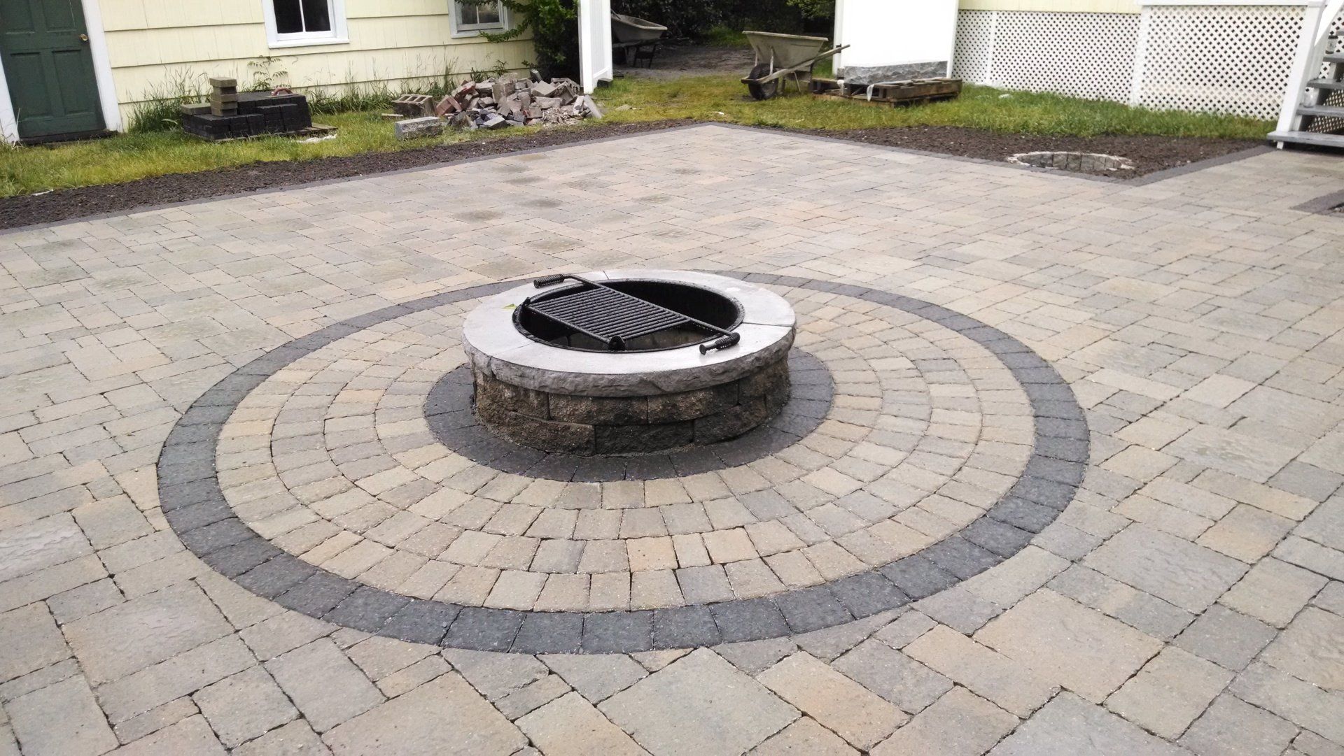 A fire pit in the middle of a brick patio