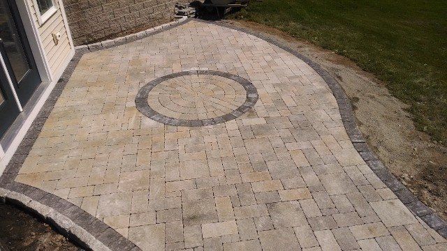 A brick walkway with a circle in the middle of it.