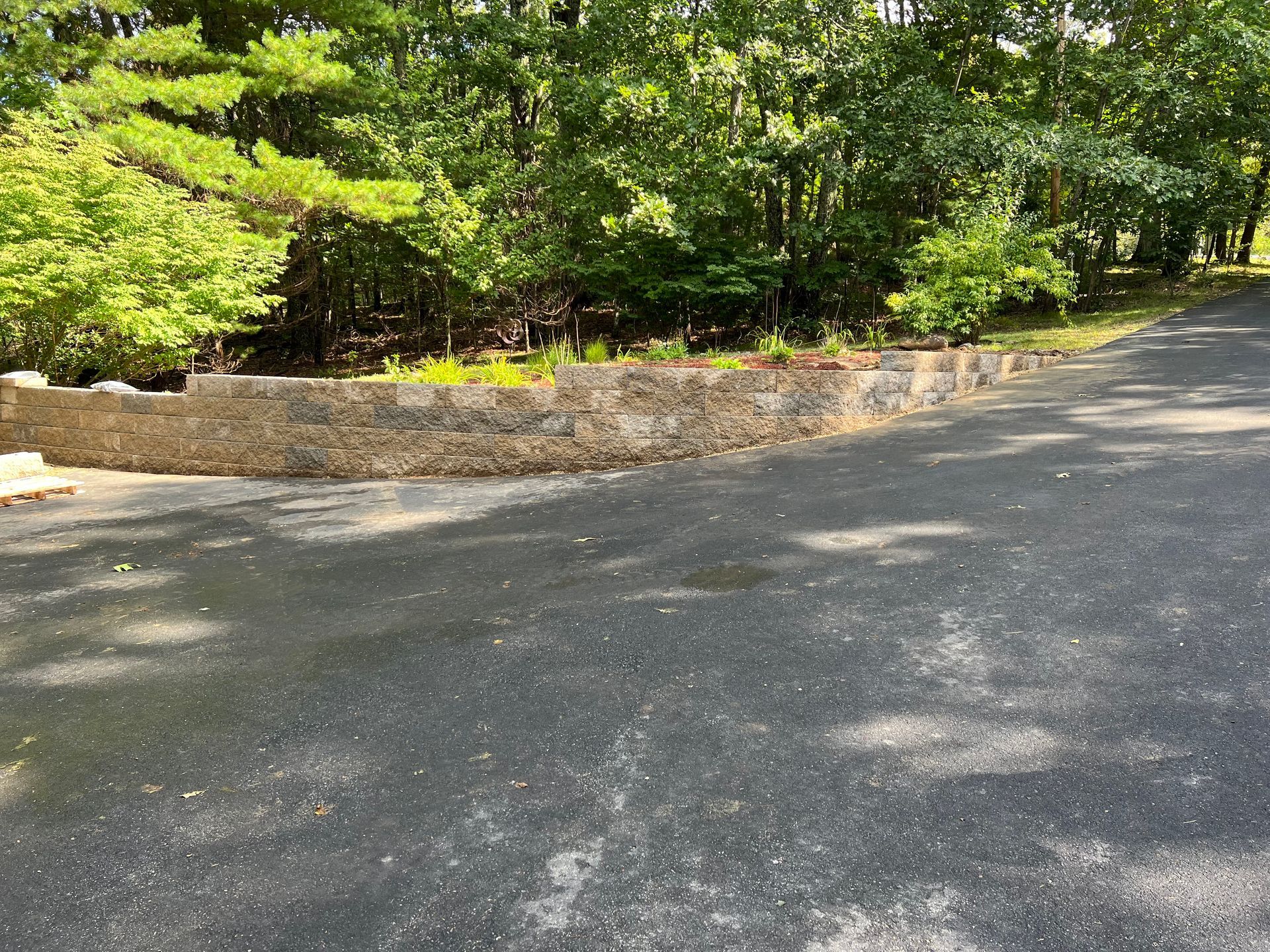 There is a stone wall on the side of the road.