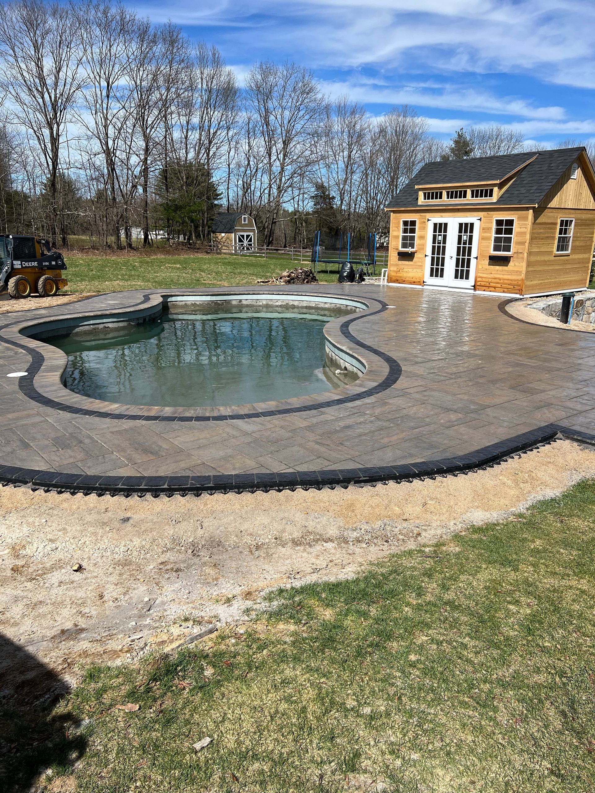 There is a large swimming pool in the backyard of a house.