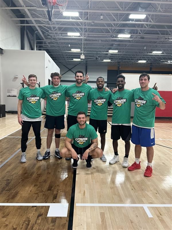 Male basketball players celebrate their championship with new t-shirts.