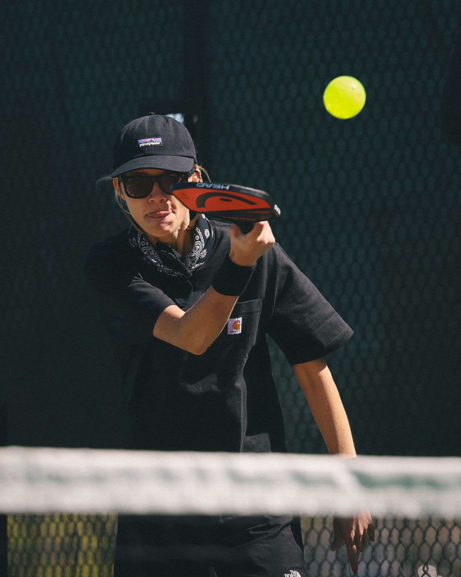 Female pickleball player concentrates on her shot.