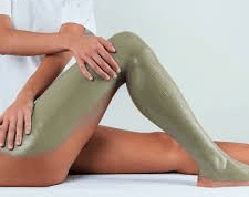 Mani che praticano un massaggio alla schiena su una persona sdraiata su un asciugamano bianco.