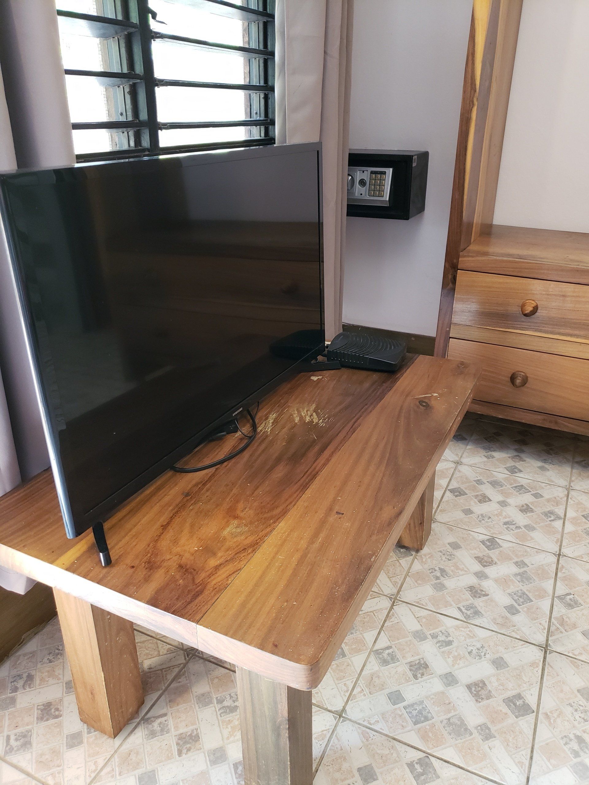 A flat screen tv is sitting on top of a wooden table.