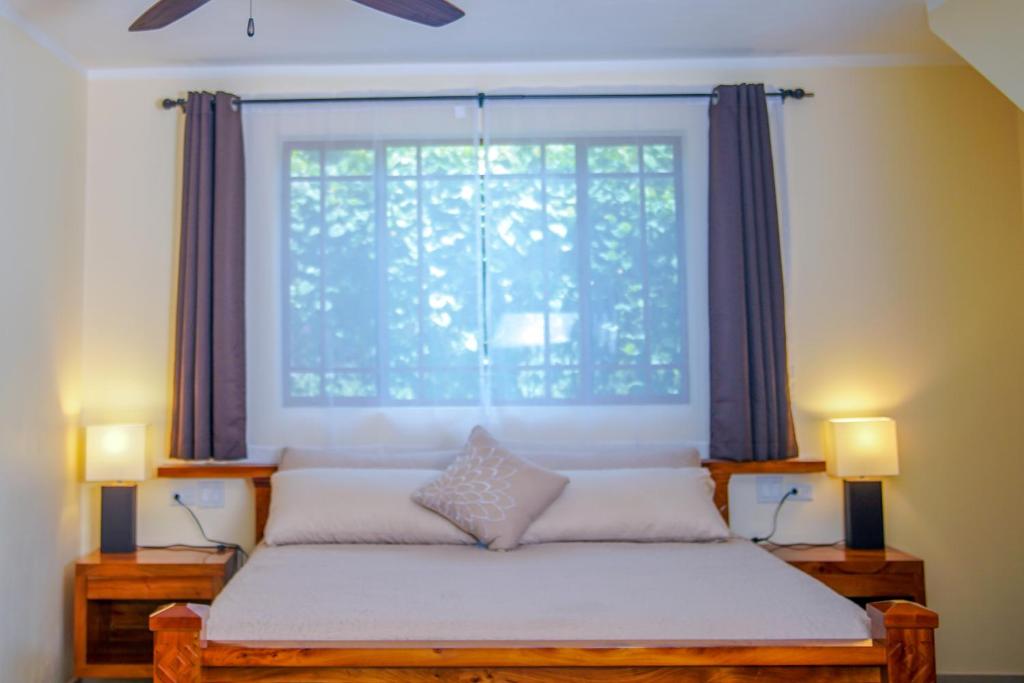 A bedroom with a king size bed and a ceiling fan.