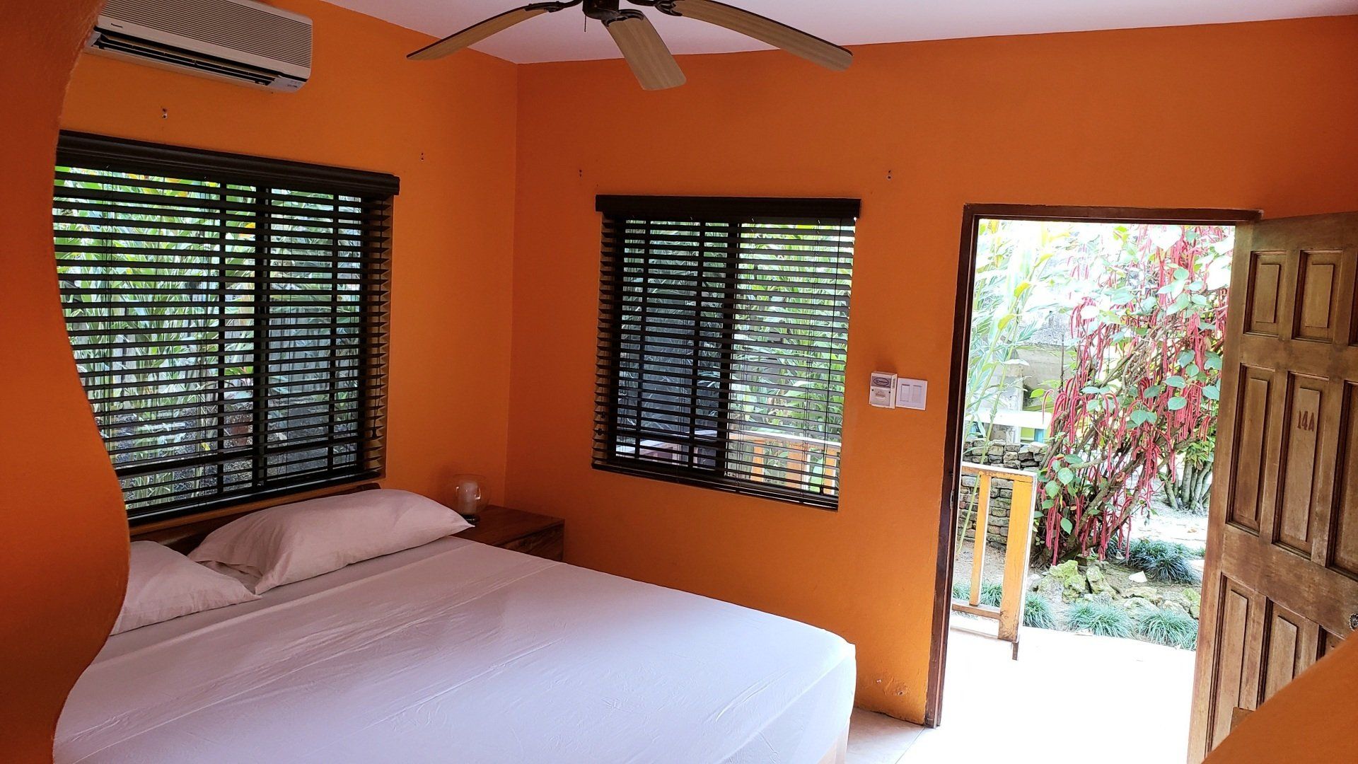 A bedroom with a king size bed and a ceiling fan