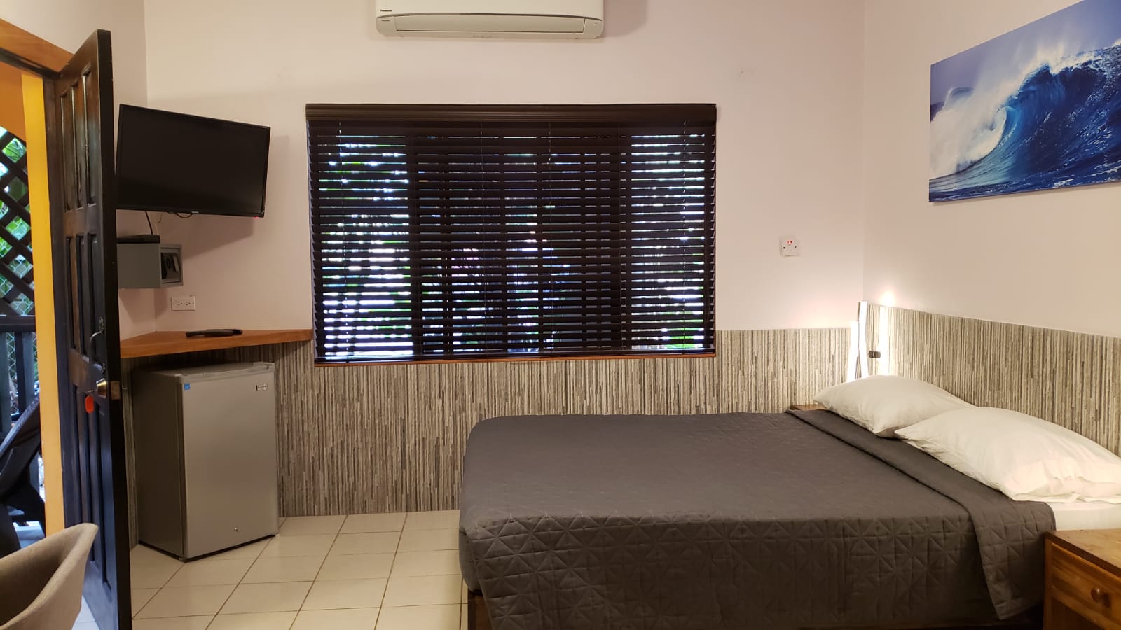 A hotel room with a king size bed and a television.