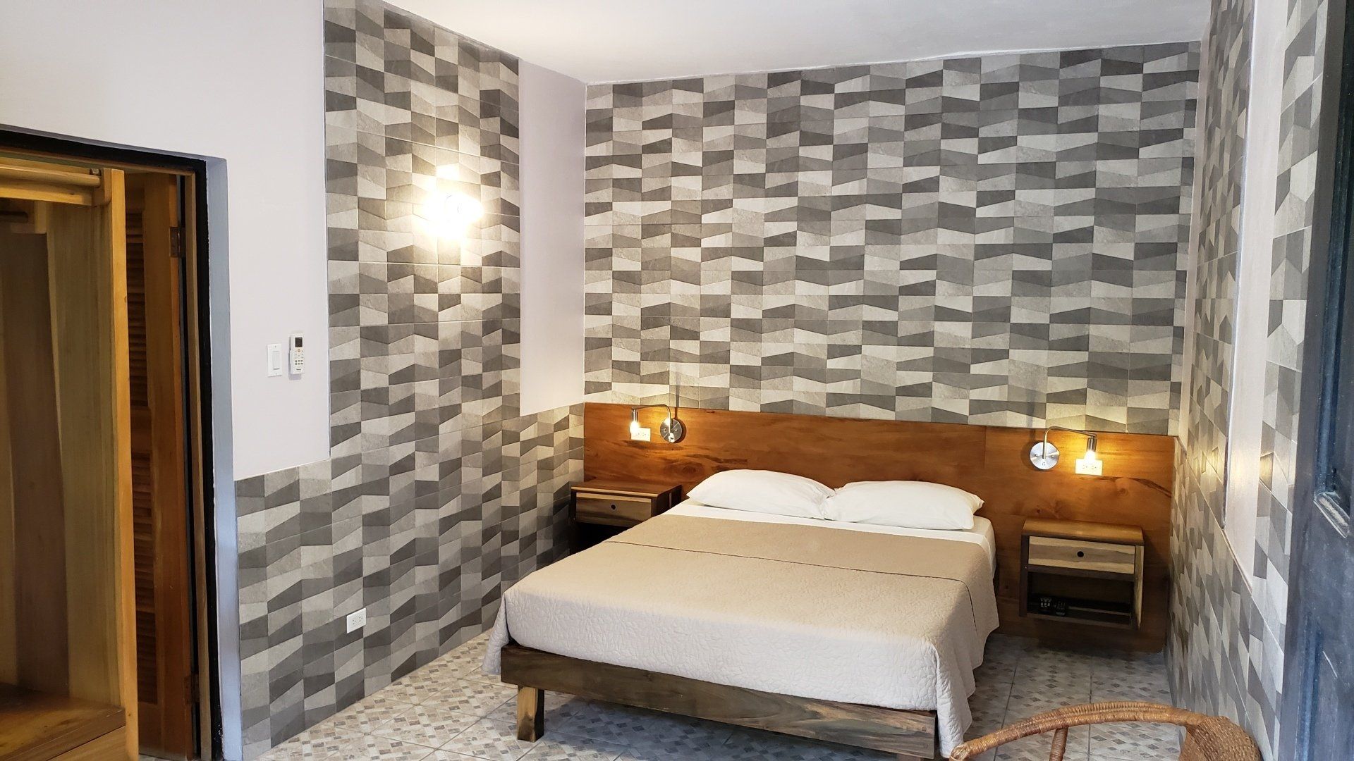 A bedroom with a bed , nightstands , and a chair.