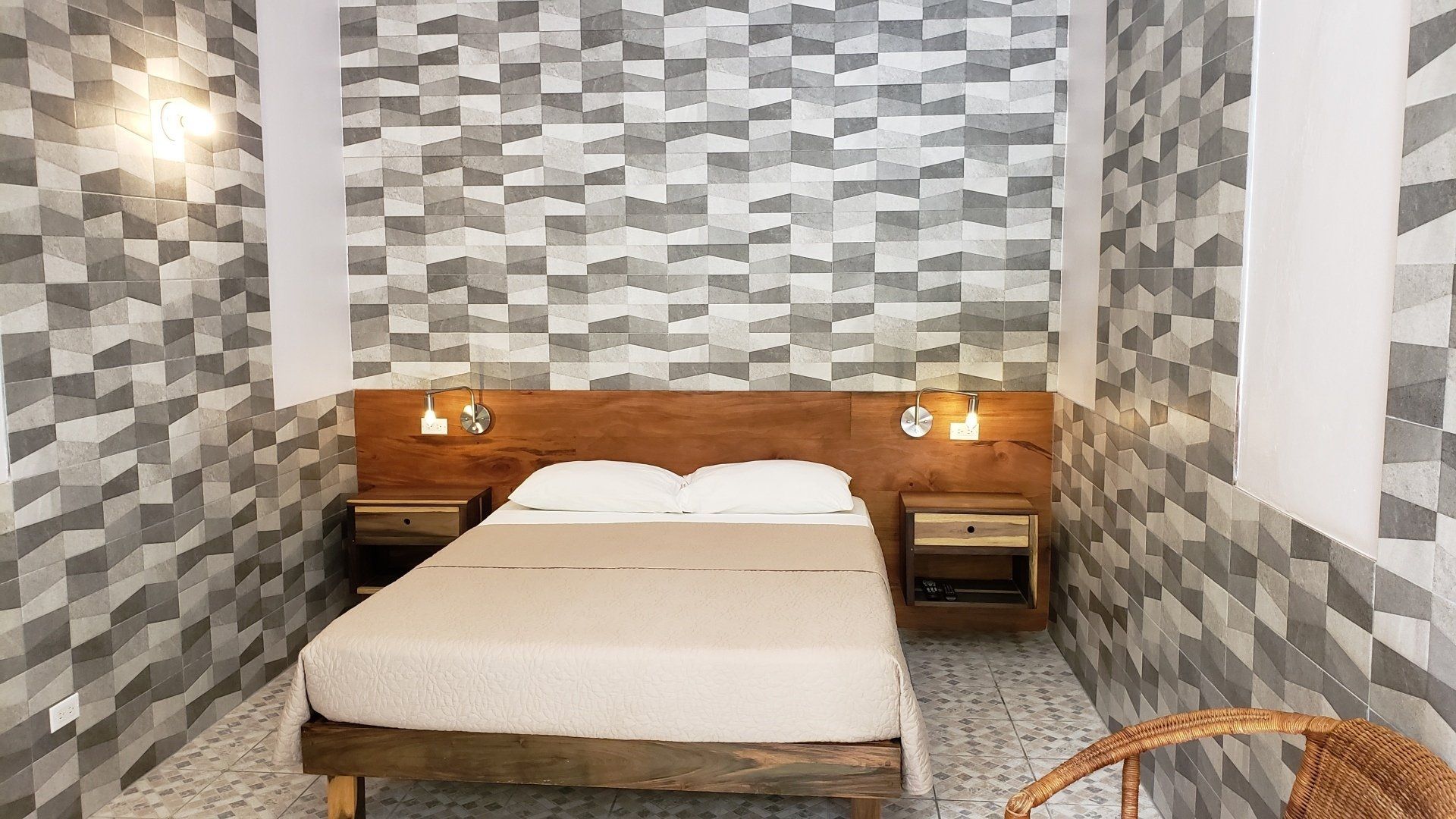 A bedroom with a bed , nightstands , and a chair.