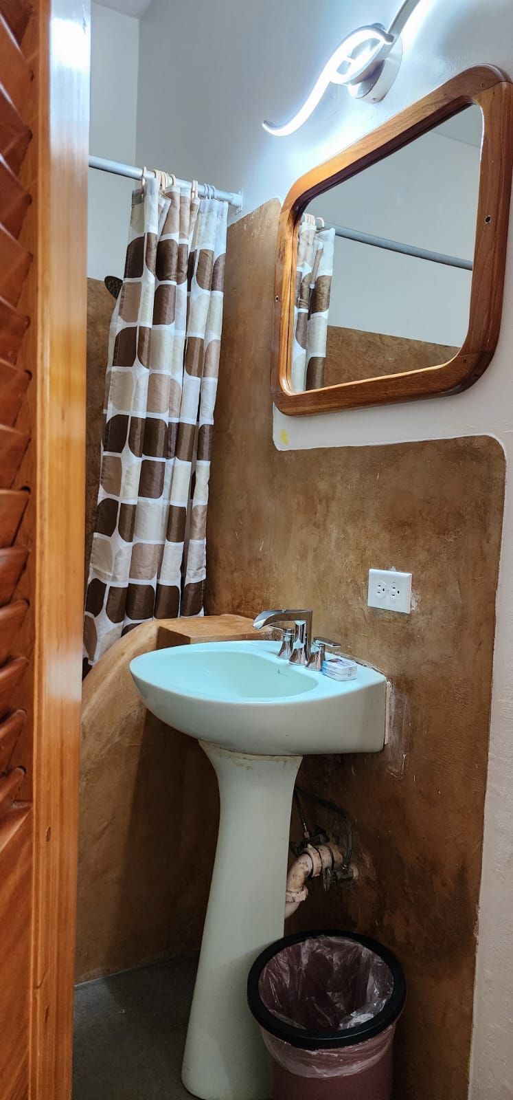 A bathroom with a sink , mirror and shower curtain.