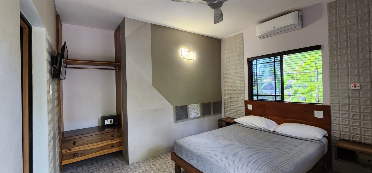 A bedroom with a king size bed and a ceiling fan.