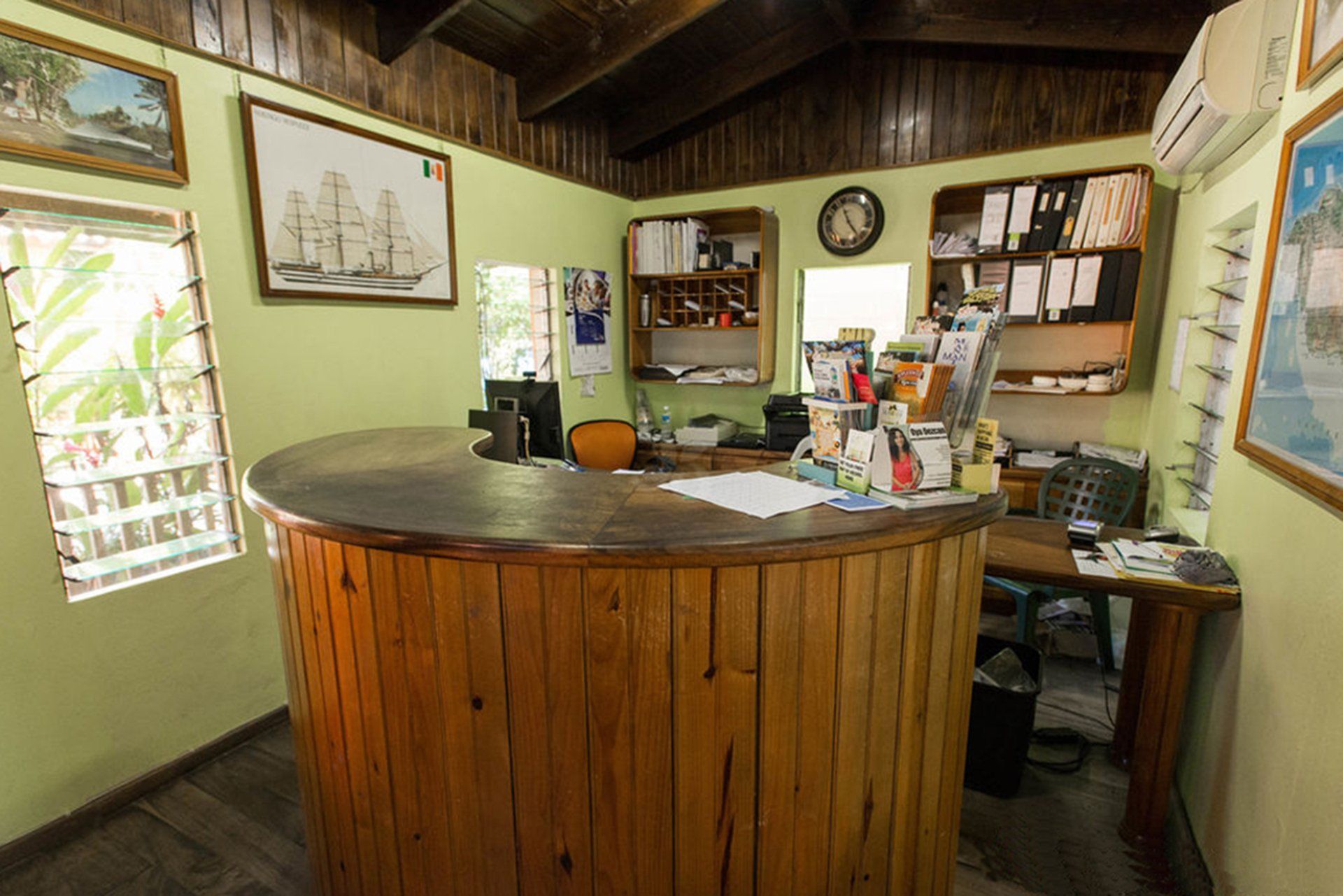 A wooden counter in a room with a clock on the wall.