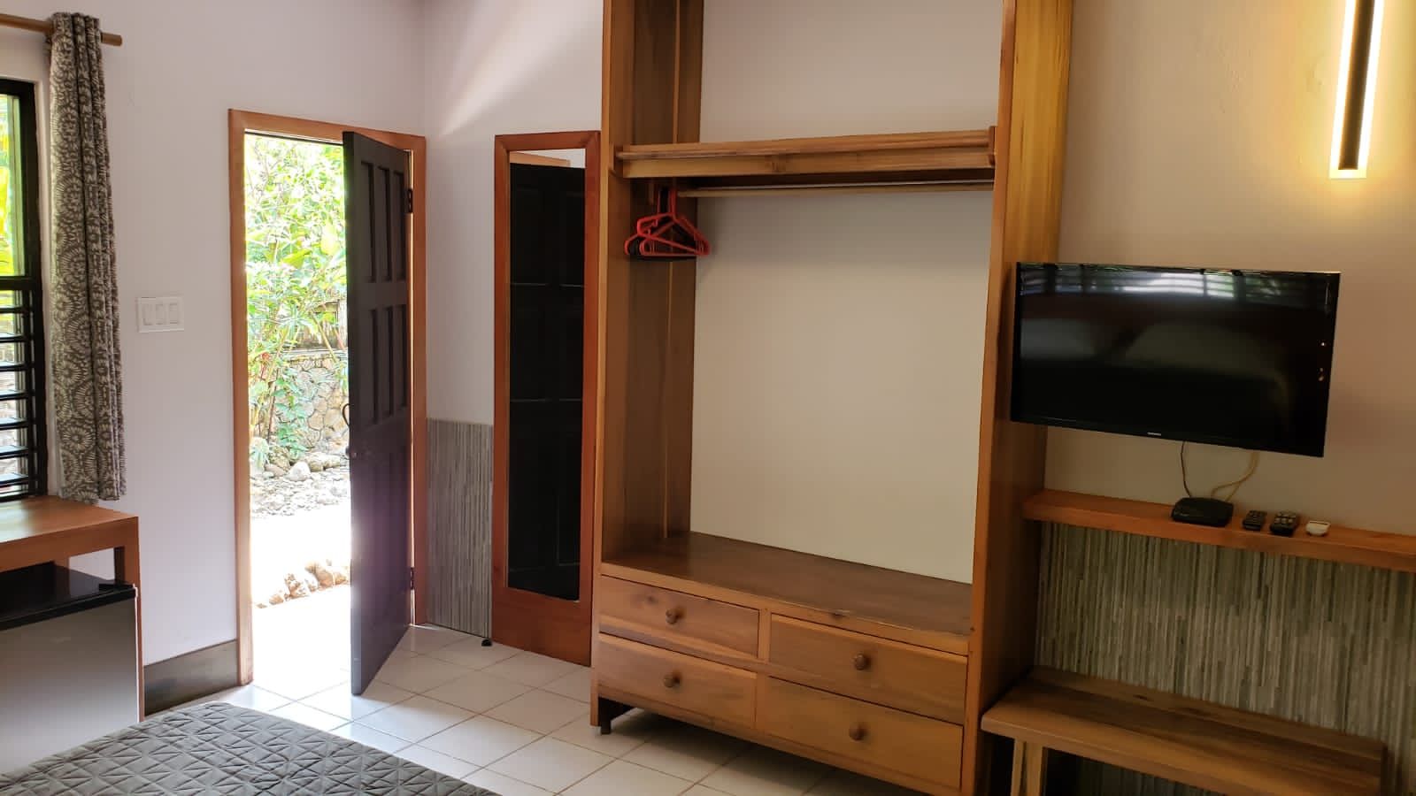A bedroom with a flat screen tv and a dresser.