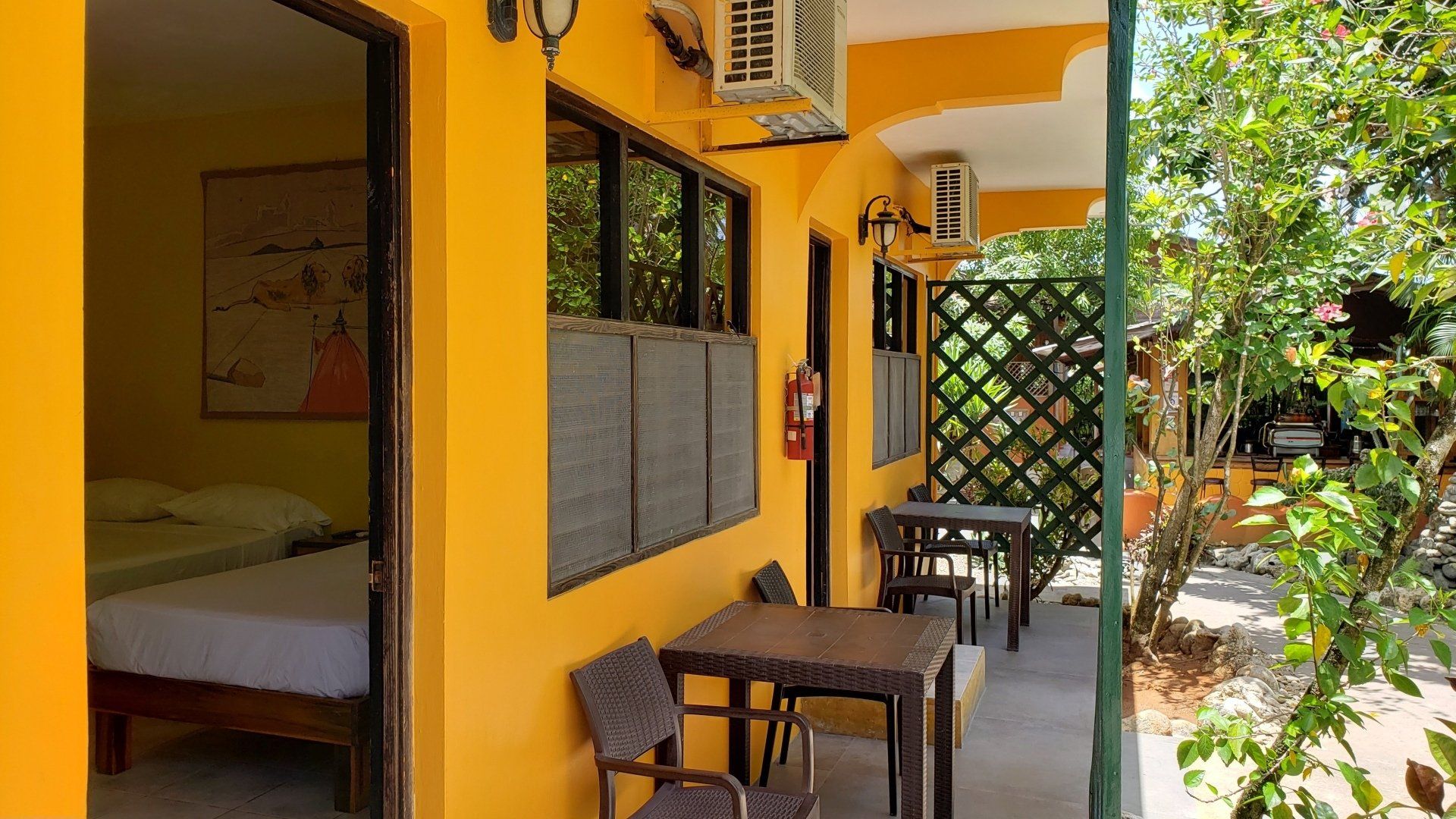 A yellow building with tables and chairs in front of it