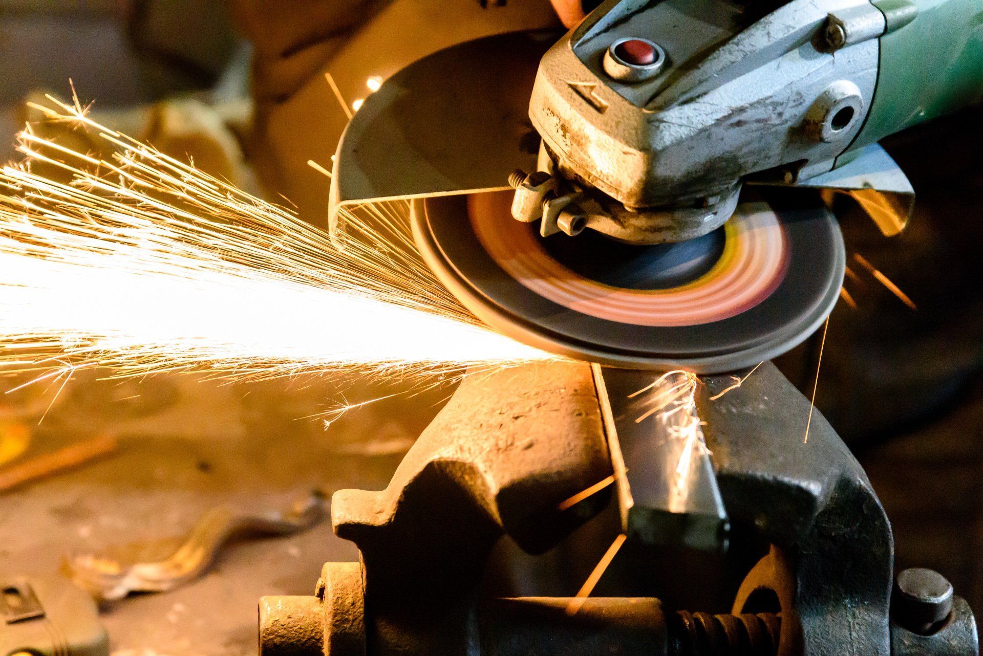 A person is grinding a piece of metal with sparks coming out of it