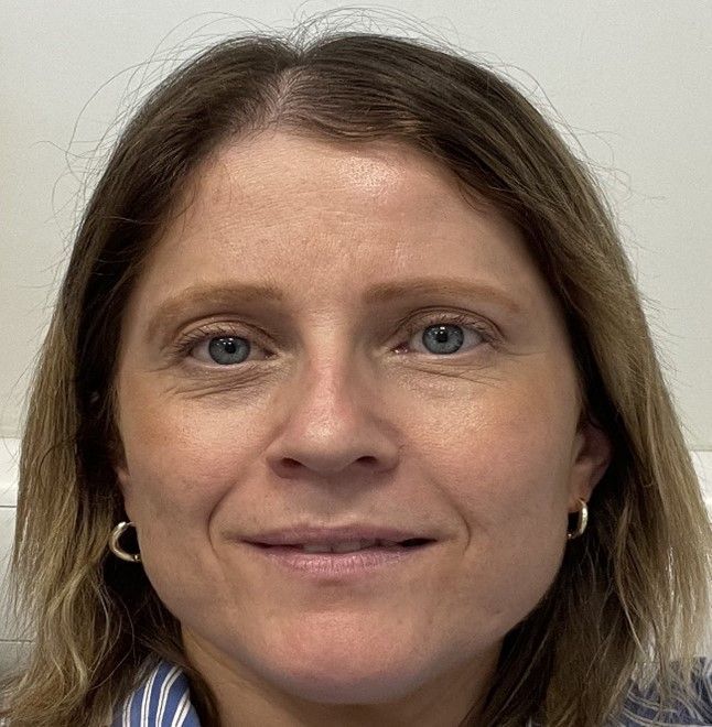 A close up of a woman 's face with a smile on her face.