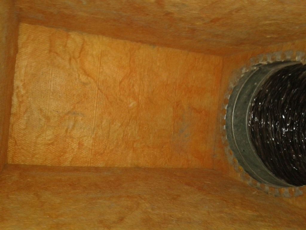 Insulated duct interior with a circular black vent opening on the right