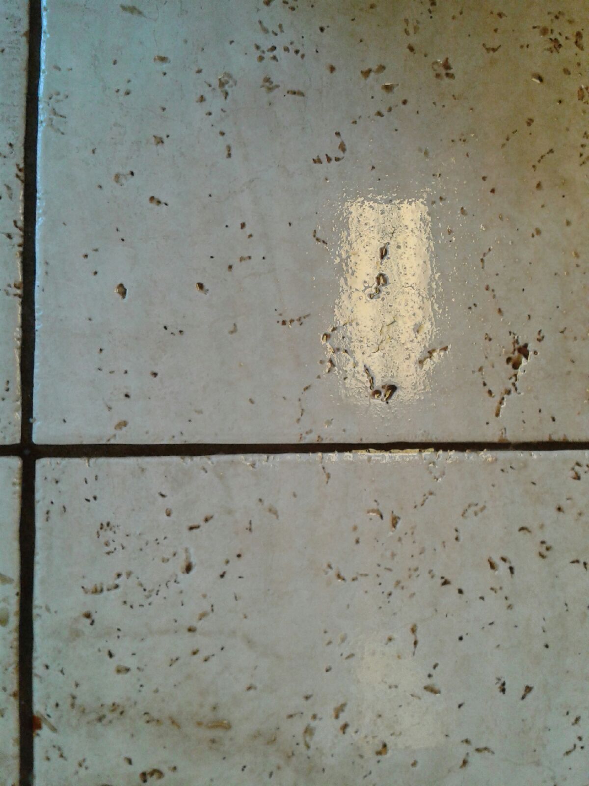 Close-up of a weathered gray metal surface with rust spots and a vertical seam.