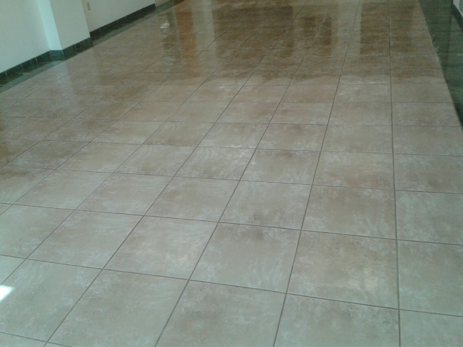 Empty indoor hallway with glossy beige tiled floor and white walls