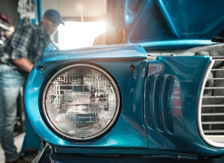 A mechanic restoring a classic car.