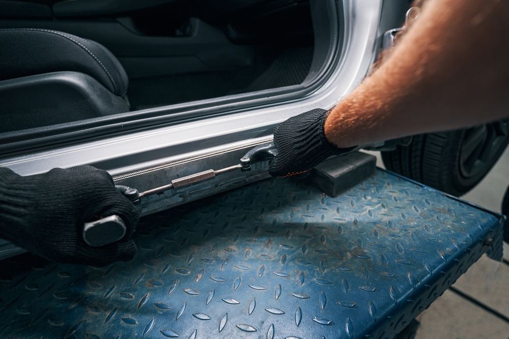 A worker repairing car frame damage.