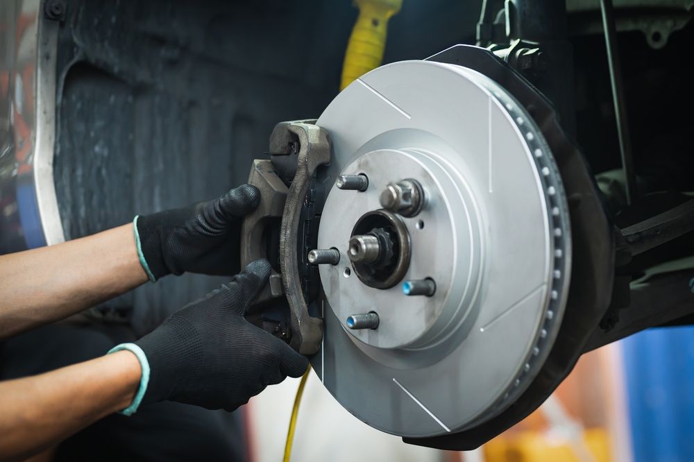 A person is fixing a brake disc on a car.