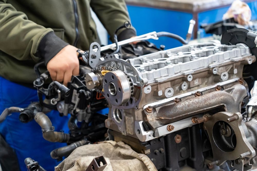 A man is working on a car engine in a garage.