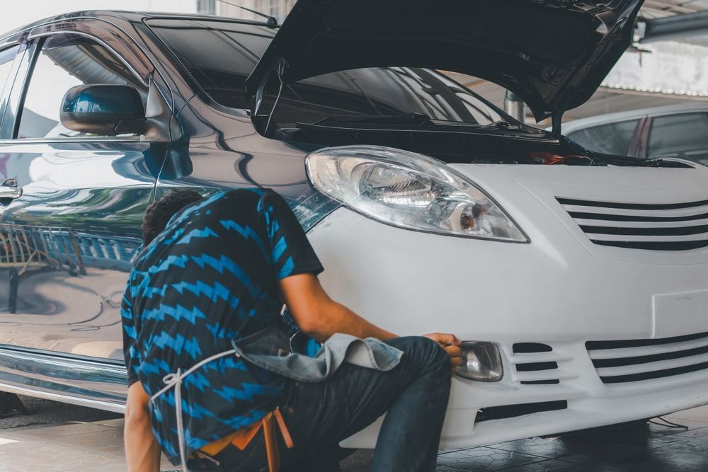 A worker repairing car frame damage.