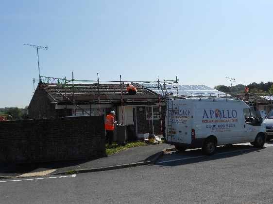 Apollo Electrical Solutions | A white van is parked in front of a house under construction.