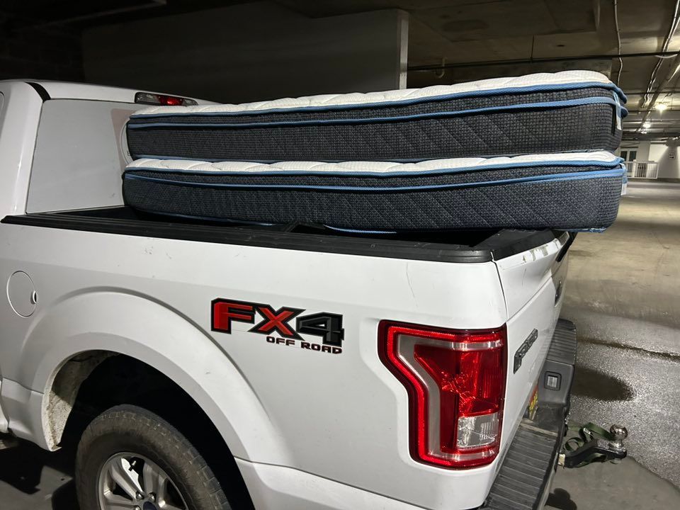 White truck bed with a mattress loaded inside.  Red 