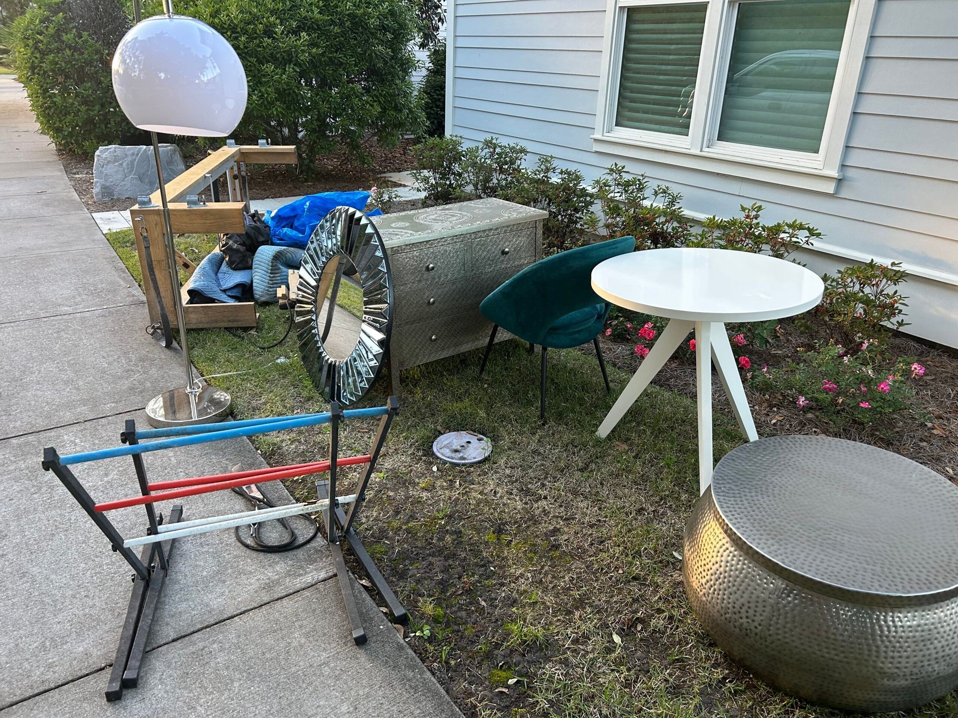 Furniture set for sale on a lawn, including a ladder toss game, mirrored chest, and side tables.