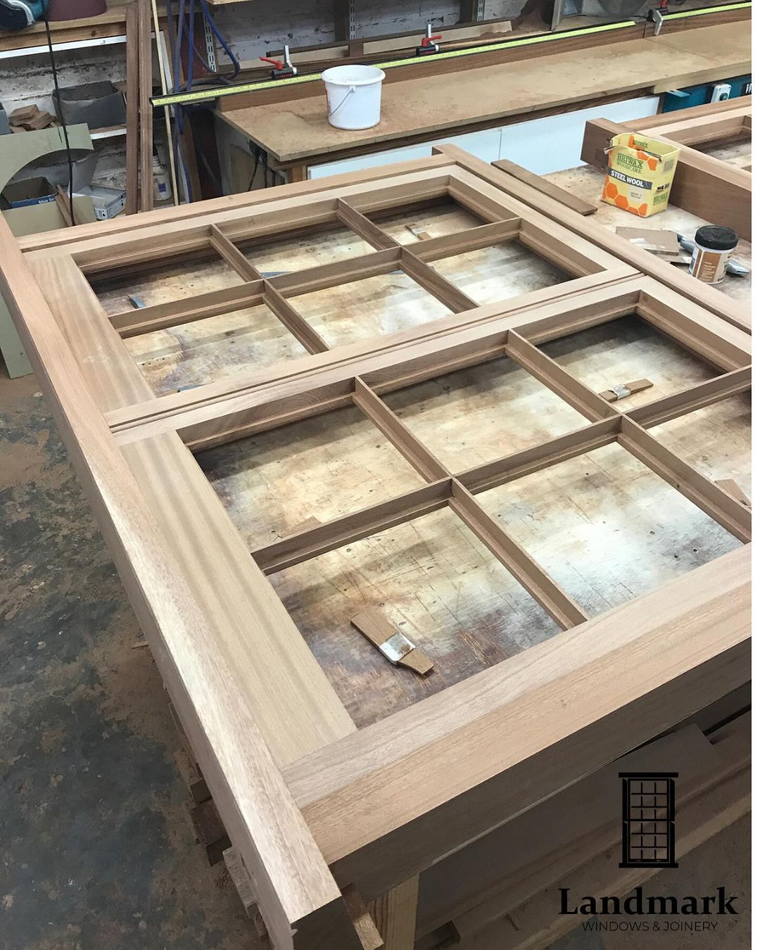 A wooden table with a window frame on it in a workshop.