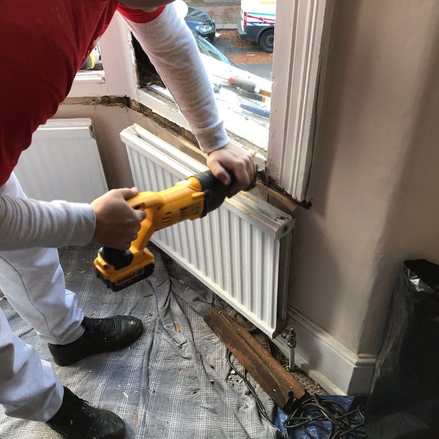 a man is working on a radiator with a drill