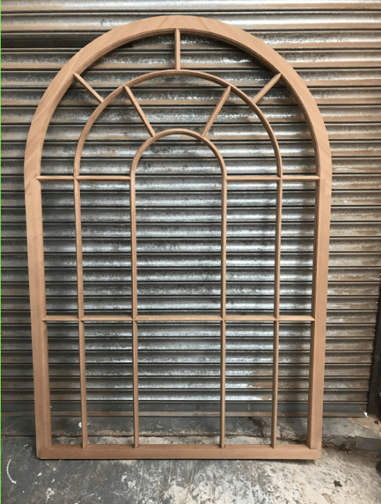 a large timber wooden sash window frame is sitting in front of a metal shutter