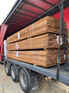 A stack of wood is sitting on the back of a truck