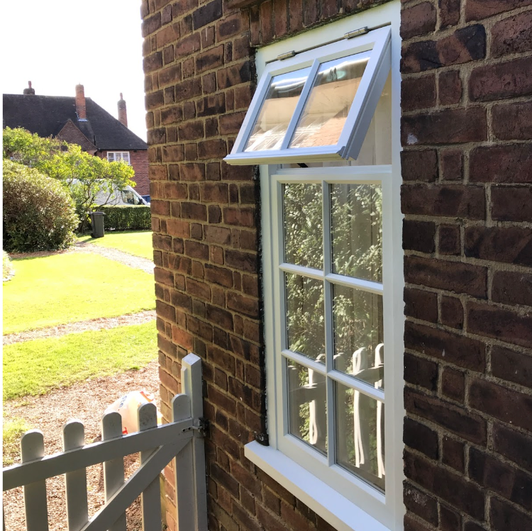 a white sash window on the side of a brick building