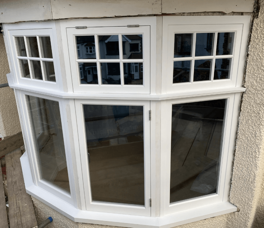 a white sash bay window on the side of a building .
