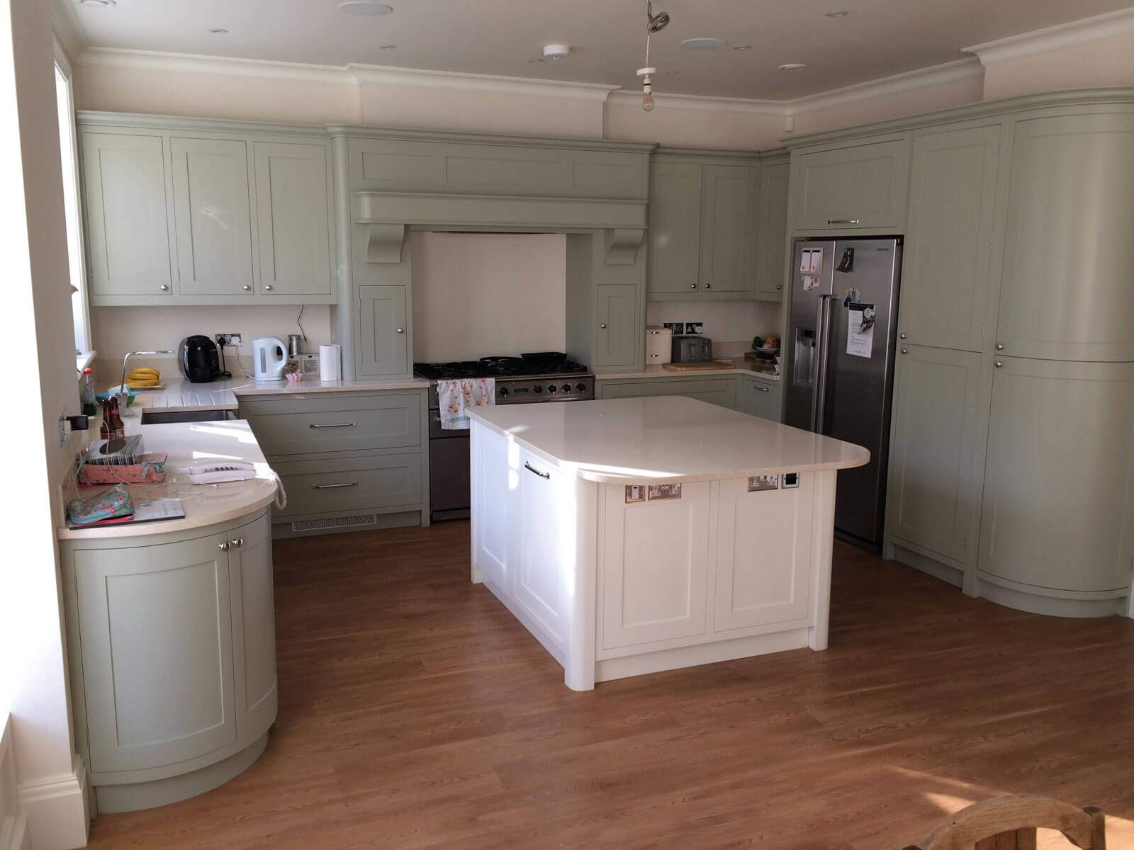 A kitchen with white cabinets and a large island in the middle