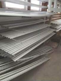 A warehouse filled with lots of metal pipes stacked on top of each other.