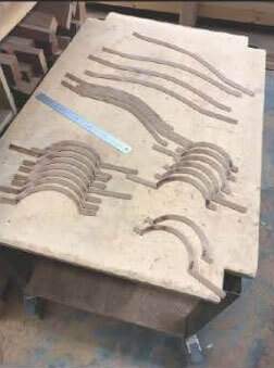 A wooden table with a ruler and a bunch of wooden pieces on it.