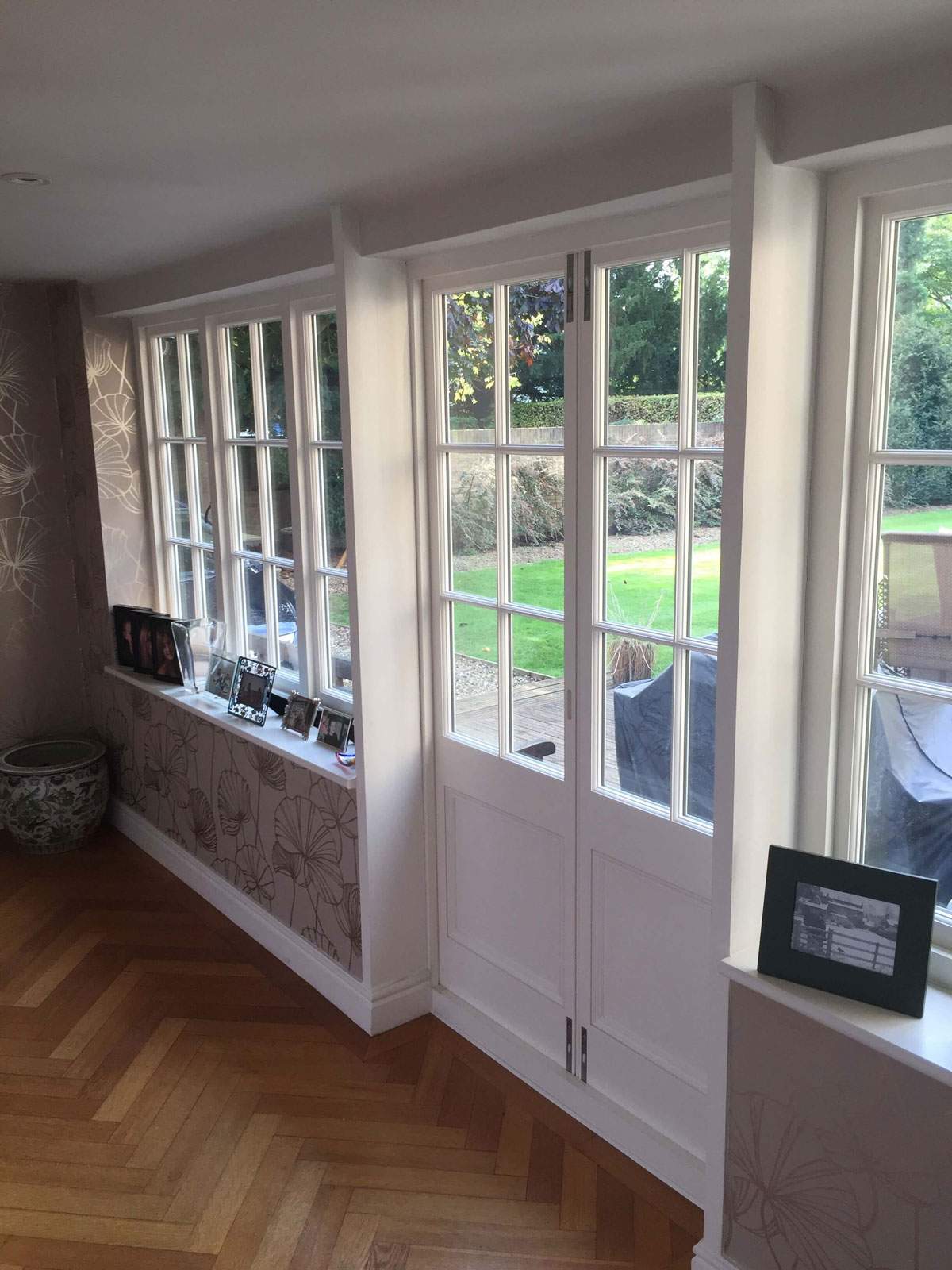 A room with a lot of windows and a wooden floor