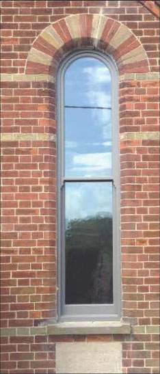 There is a large window on the side of a brick building.