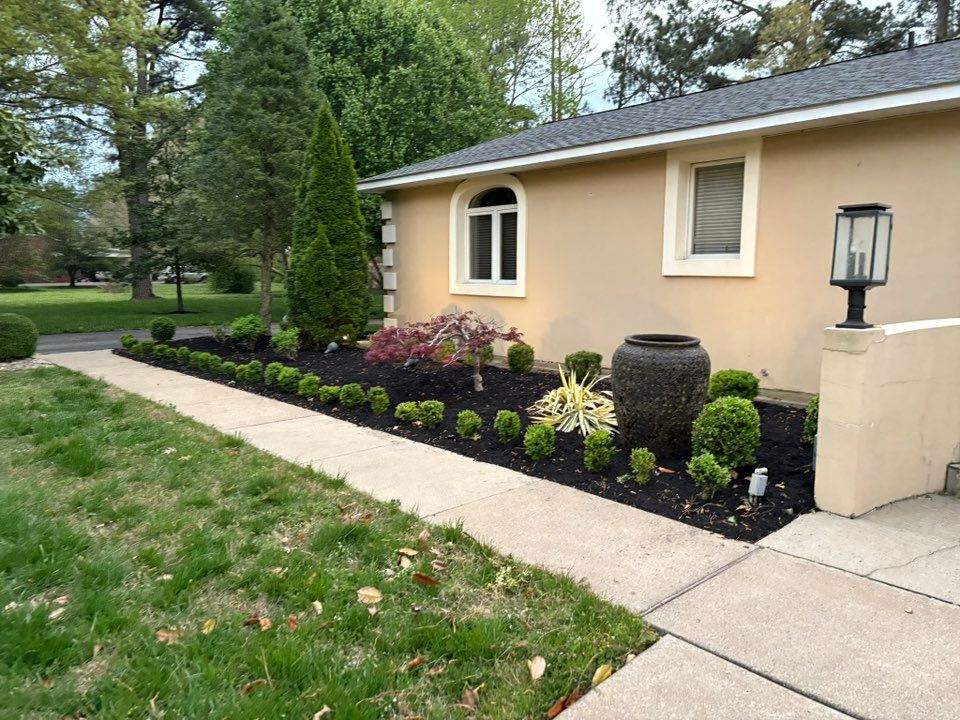 House exterior with manicured landscaping, shrubs, and sidewalk.