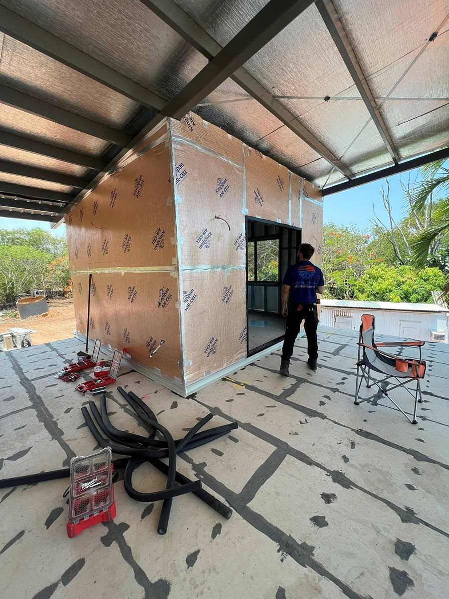 A Man Is Standing In Front Of A Building Under Construction — COOLIT NT In Berry Springs, NT