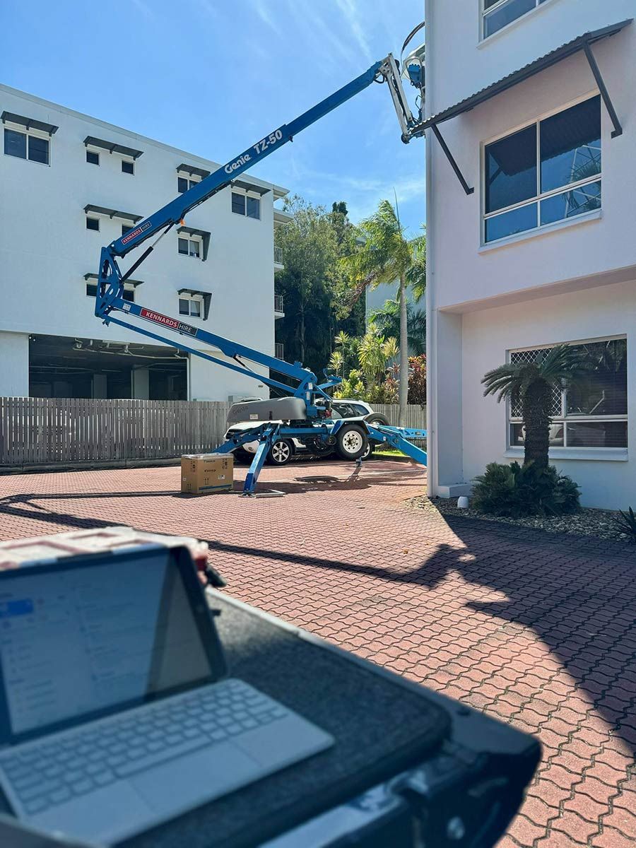 A Laptop Is Sitting On A Desk In Front Of A Building With A Crane In The Background — COOLIT NT In Noonamah, NT
