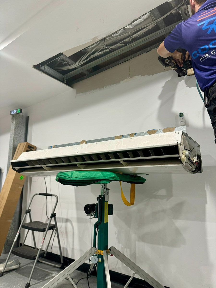 A Man Is Working On An Air Conditioner In A Room — COOLIT NT In Darwin, NT