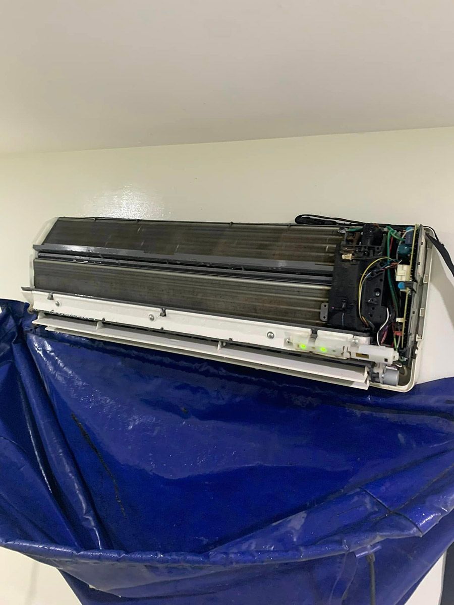 An Air Conditioner Is Sitting On Top Of A Blue Cloth On A Wall — COOLIT NT In Berrimah, NT